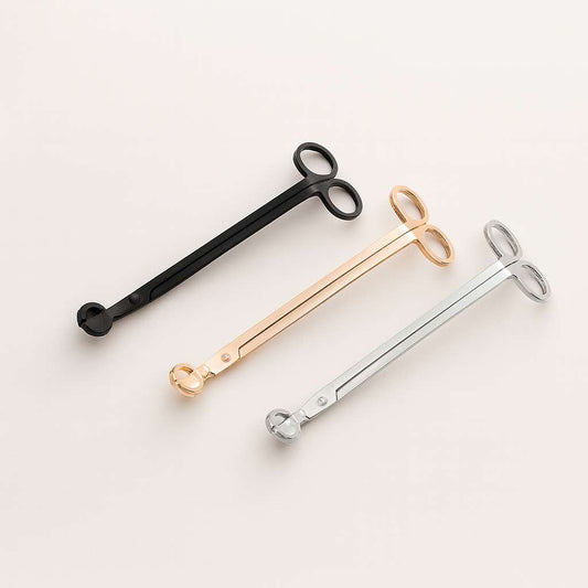 Set of three premium candle wick trimmers in silver, gold, and black.