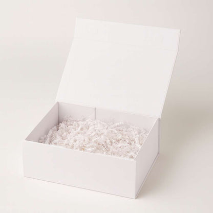 White magnetic candle gift box with shredded paper for luxury packaging.