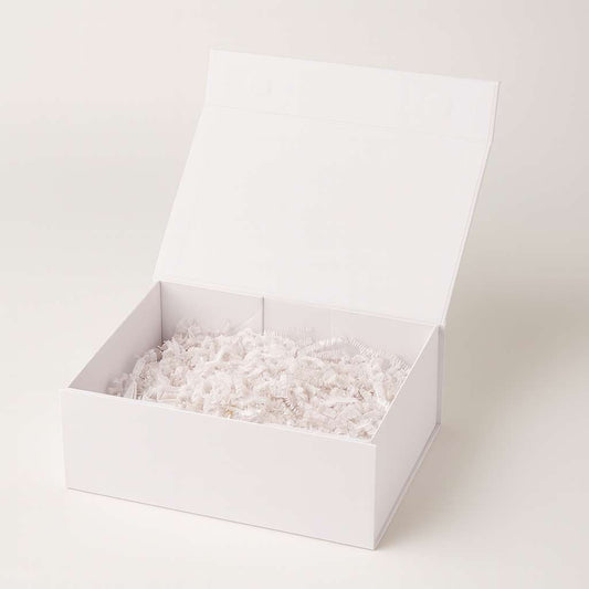 White magnetic candle gift box with shredded paper for luxury packaging.