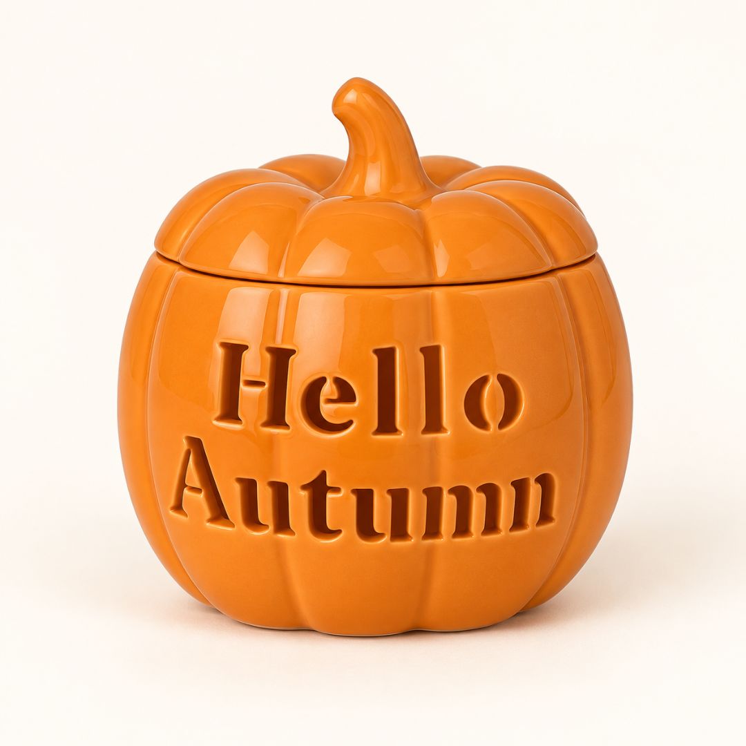 An orange pumpkin-shaped ceramic jar with a lid, featuring the embossed text 'Hello Autumn' on the front, set against a plain white background.